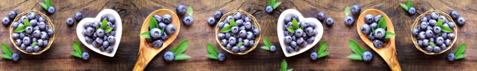 Fresh blueberries in wooden spoons and heart bowls on rustic wooden background