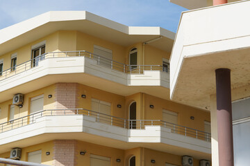 A plain urban structure with simple railings and old AC units marks a typical coastal street. Great for property investors, apartment renters, and foreigners seeking city housing abroad.