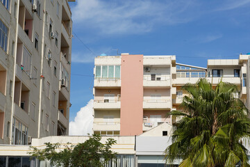 A compact mid-rise building with boxy balconies and visible AC units mounted on the façade. Great...