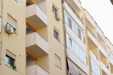 Cream-toned building with modest balconies blends into a typical Albanian coastal neighborhood....
