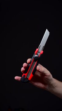 Retractable utility knife.
Universal paper cutter.
Retractable blade cutter on a black background.