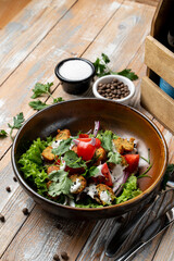 A vibrant dish of crispy lettuce, diced tomatoes, and flavorful herbs is artfully arranged in a rustic bowl, offering a healthy meal option. Perfect for lunchtime gatherings or enhancing a buffet