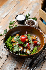 Colorful bowl filled with crispy tofu, fresh lettuce, juicy tomatoes, and fragrant herbs rests on a rustic wooden table. Simple yet nourishing, this dish invites healthy eating
