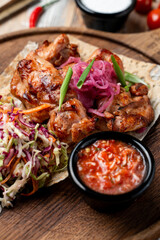 Savor the flavors of grilled chicken, perfectly cooked and served with fresh vegetable salad and zesty salsa on a wooden platter, creating a warm, inviting meal experience