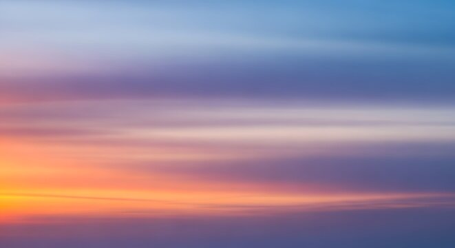 Abstract blurred background of a colorful sunset sky with shades of orange purple and blue hues
