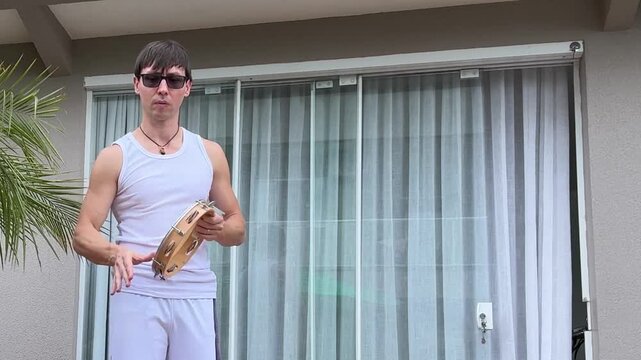 homem tocando pandeiro samba em casa 