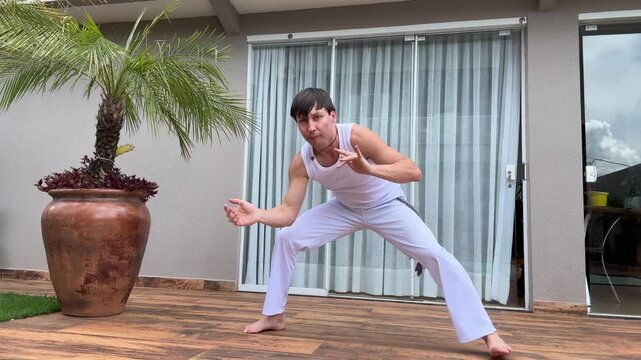 homem treina capoeira em casa, cultura africana brasileira 