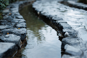 Beautiful water in the park. Natural calming background. Artificial stream.