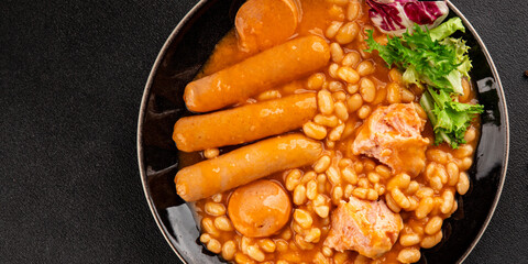 Beans with meat in tomato sauce cassoulet sausages, pork main course tasty snack fresh delicious gourmet food table setting rustic food top view copy space