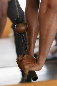 Man is performing triceps pushdowns on a cable machine to strengthen his arms and upper body