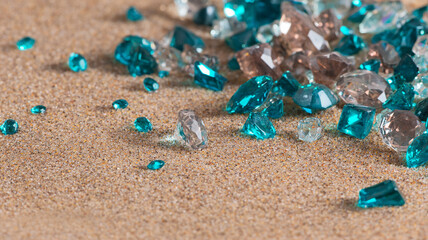 photo of turquoise crystals scattered on the sea sand, can be used as poster or banner