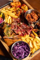 Large BBQ meat platter with fries and sides
Hearty grilled meat assortment served on a wooden board
Rustic BBQ feast featuring beef, chicken, and crispy fries