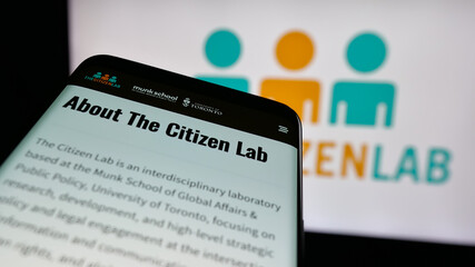 Fototapeta premium Stuttgart, Germany - 11-19-2025: Mobile phone with website of Canadian research laboratory Citizen Lab on screen in front of logo. Focus on top-left of phone display.