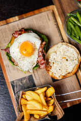 Gourmet burger topped with a fried egg and crispy bacon
Classic beef burger served with fries and fresh ingredients
Delicious egg-topped burger on a rustic wooden board