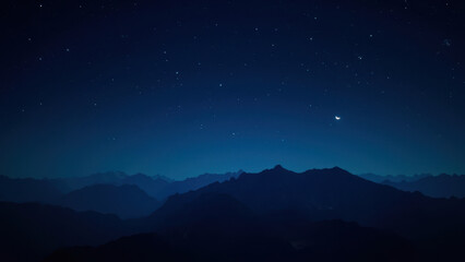 Naklejka premium Night sky over mountain range with stars and crescent moon