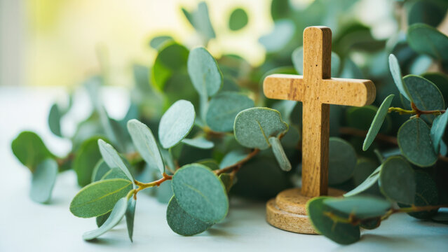 Wooden cross with eucalyptus leaves, a symbol of faith and spirituality
