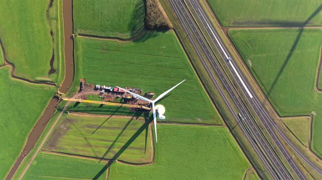 Wind Turbine Construction with Crane Installing Rotor Blades

