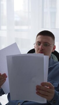 Documents on a businessman's desk.
The man is holding a stack of documents and reading them carefully.
Information on paper.
Paperwork in the HR department.
Resume, job, office, vacancy,
