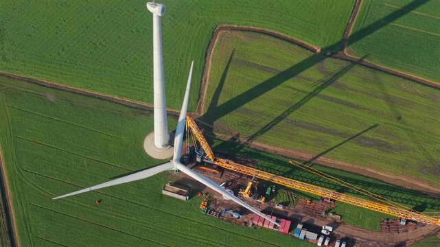 Wind Turbine Construction with Crane Installing Rotor Blades
