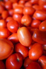 Fresh red tomatoes piled together in a vibrant display at a local farmers market in early summer