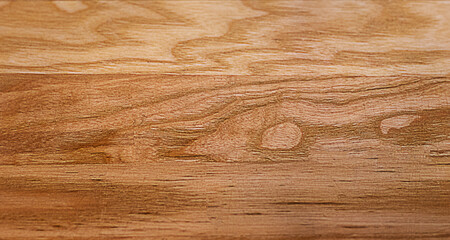 Close up of warm wooden tabletop texture with natural grain patterns and knots