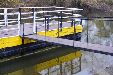 Waterfront dock with reflective surface and simple design at peaceful river location during early afternoon