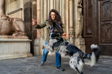 Woman and dog enjoying playful interaction outdoors, reinforcing their bond