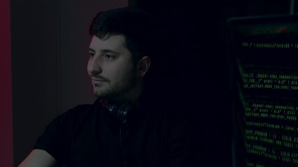 Male artificial intelligence engineer, focused on coding at a computer desk, illuminated by ambient lighting, showcasing concentration and expertise in technology