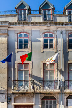 Facade of a building from the end of the 19th century, on Madalena Street, with Pombaline architecture, with the flags of Potugal and the European Union flying. Lisbon, 2023