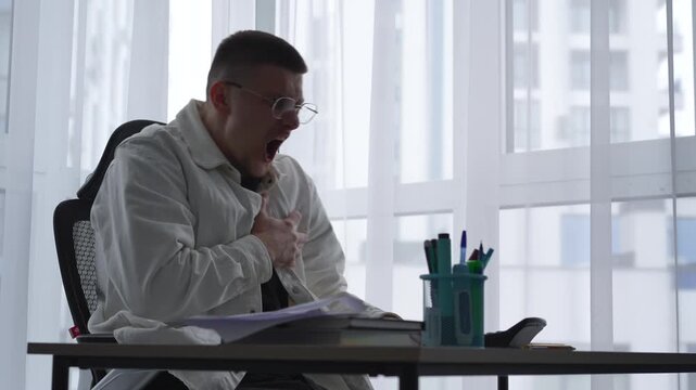 A businessman suffers a sudden heart attack in his office.
A guy in a white shirt has cardiac problems.
An office worker experiences chest pain and difficulty breathing.
Chest, pain, cardio, tremors