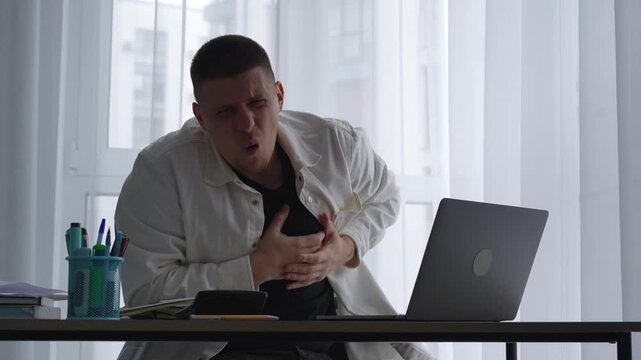 A businessman suffers a sudden heart attack in his office.
A guy in a white shirt has cardiac problems.
An office worker experiences chest pain and difficulty breathing.
Chest, pain, cardio, tremors