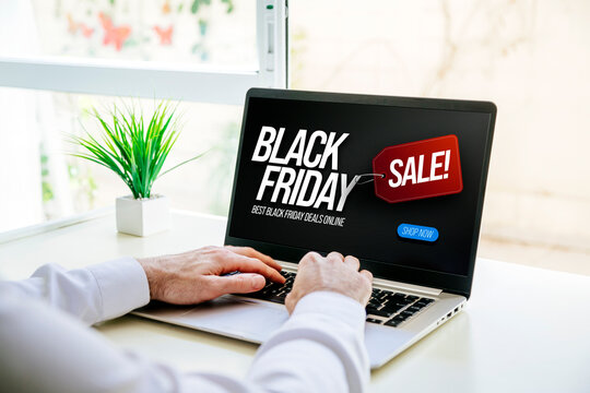 Black Friday deals. Man with a laptop showing an advertisement with discount offers to buy online now.