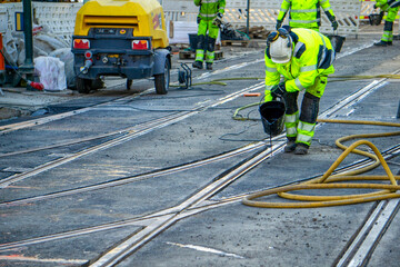 Oslo Tram Track Grouting: Construction Worker Pours Polyurethane Elastomer Sealant into Rail Joint