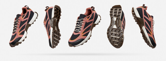 Flying black pink unisex sneakers from different sides on gray background. Creative concept of...