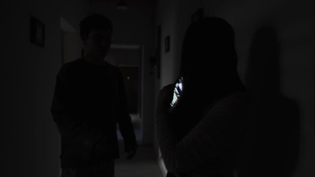 Husband catches wife secretly texting in the hallway, relationship distrust and jealousy