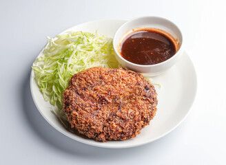 apanese menchi katsu. This crispy, juicy cutlet is served with fresh cabbage and a delicious sauce, ready to be enjoyed