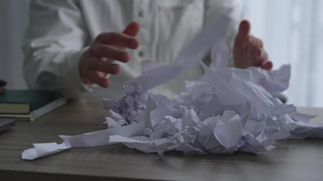 An angry businessman scatters torn and wrinkled paper around the office.
A man is having problems at work.
A man has a nervous breakdown at work and tears up paper.
Paper, stress, nerves, emotions