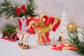 Christmas candy cane shortbread cookies in a clear glass vase with Christmas decor on a light tablecloth. Merry Christmas.