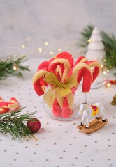 Christmas candy cane shortbread cookies in a clear glass vase with Christmas decor on a light tablecloth. Merry Christmas.