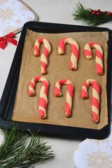 Step-by-step preparation of Candy Cane shortbread cookies in Christmas decor on a light concrete background. Merry Christmas!