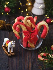 Christmas candy cane shortbread cookies in a clear glass vase with Christmas decor on a dark wooden background. Merry Christmas.