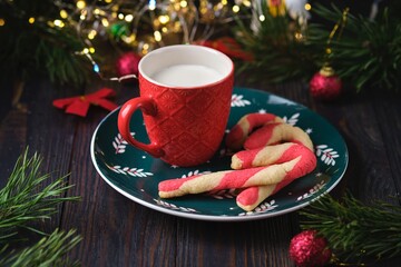 Christmas candy cane shortbread cookies on a green plate with Christmas decor against a dark wooden background. Merry Christmas.