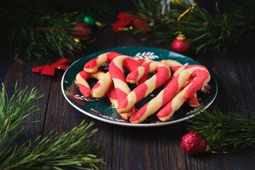 Christmas candy cane shortbread cookies on a green plate with Christmas decor against a dark wooden background. Merry Christmas.
