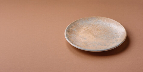 An empty round ceramic plate on a table, kitchenware. An empty plate