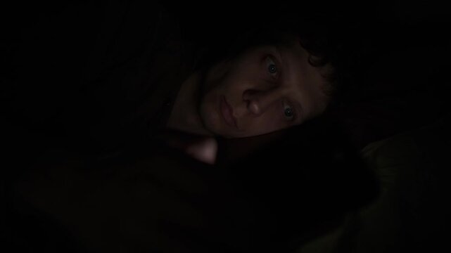Man addicted to smartphone at night, social media dependence, compulsive scrolling