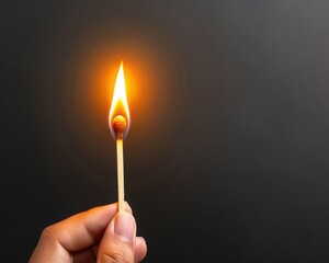 A hand holding a burning matchstick against a dark background.