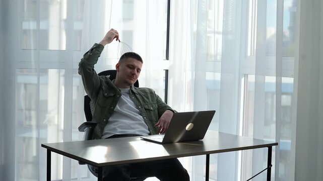 A man massages his head at work, wanting to take a break from work and office stress.
Rest and relaxation at work.
A businessman massages his head and enjoys it.
Pleasure, massage, head, relaxation