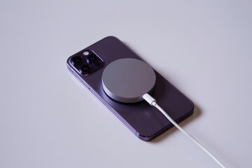 Close-up high-resolution image of a smartphone with a circular magnetic accessory on the back, highlighting ease of use and tech