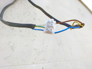 Electrical wiring connected via a plastic terminal block. Several wires are secured in the...