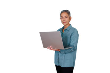 Senior businesswoman standing, working on laptop, confident and focused while using technology for professional tasks
